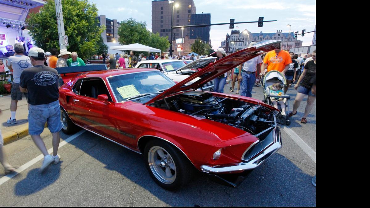 
Spectators check out a 1969 Mustang Mach I at the Automobilia Car Show in July, 2013.
