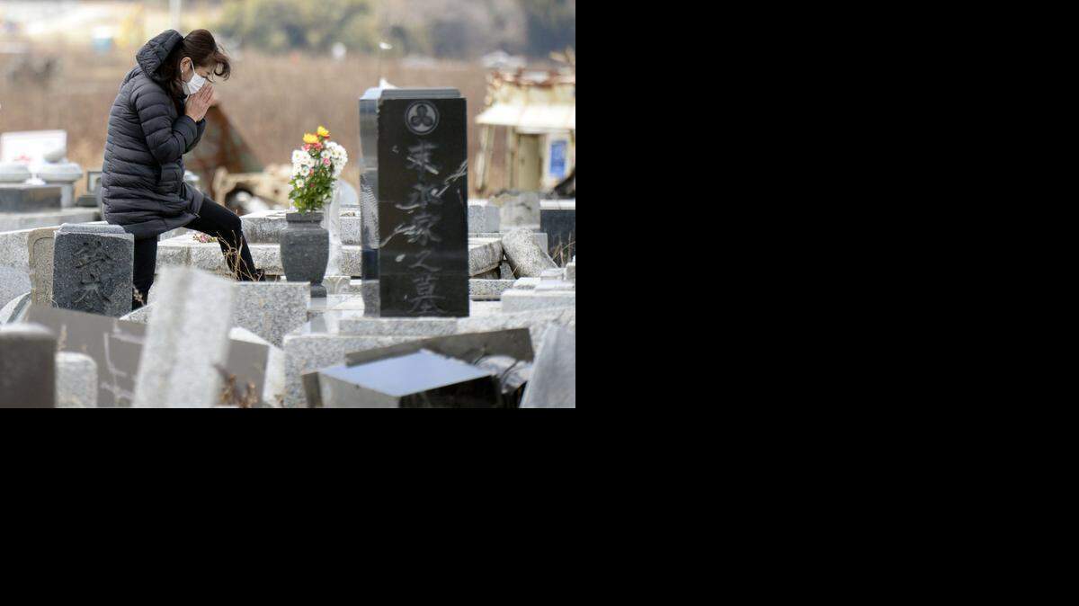 
A woman prays in front of her ancestors’ tomb which was damaged by the March 11, 2011, earthquake and tsunami, in Namie, Fukushima prefecture, northern Japan, on Wednesday, March 11, 2015. Japan marked the fourth anniversary on Wednesday of the devastating disasters that left nearly 19,000 people dead or missing.
