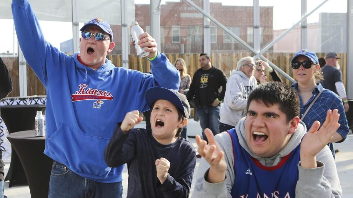 The glass tent at the Brick and Mortar Event Venue is one of many places hosting parties and rallies during the NCAA Tournament. Left to right: Kansas fans Clay Williams, Manny Rodriguez and Jose Rodriguez.
