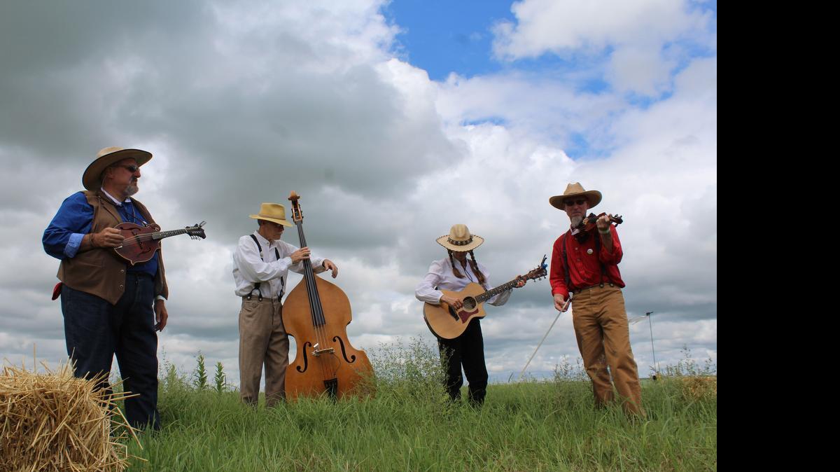 
Tallgrass Express String Band musicians, from left, Jim Versch, Carl Reed, Anne Wilson and Kim Schmidt provide the welcome music for guests of the Symphony in the Flint Hills. Despite weather concerns, the event, held at the Tallgrass Prairie National Preserve, was expected to draw more than 7,000 concertgoers from all over the world. 

