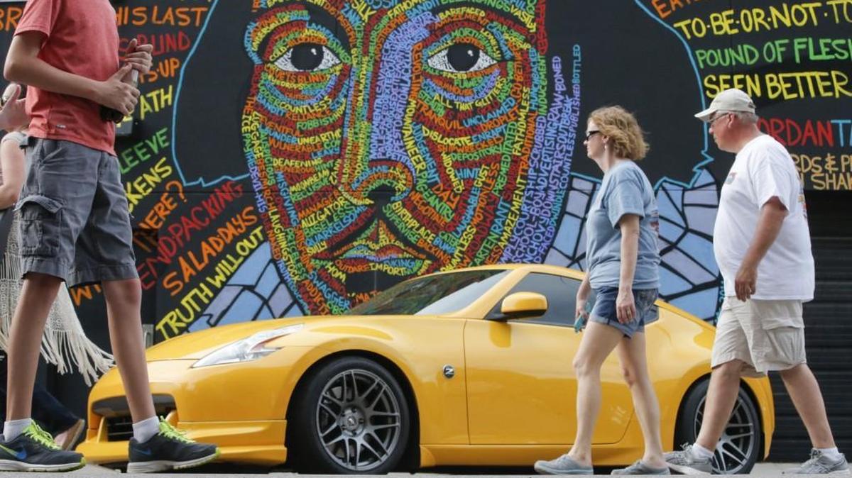 Car enthusiasts takes in the sight during the 21st annual Automobilia Moonlight Car Show and Street Party in downtown Wichita on Saturday night.