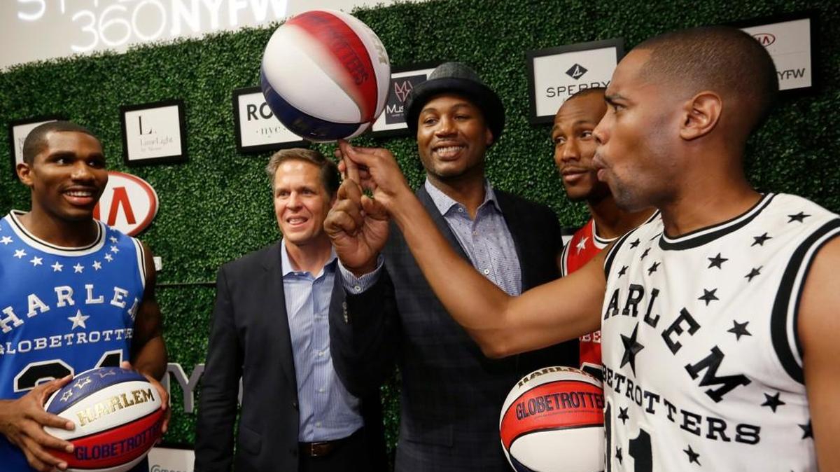 
Harlem Globetrotters, from left, Thunder Law, CEO Kurt Schneider, Smooth Staples and Cheese Chisholm spin the ball with former World Heavyweight Champion Lennox Lewis, center, during a New York Fashion Week show last month.
