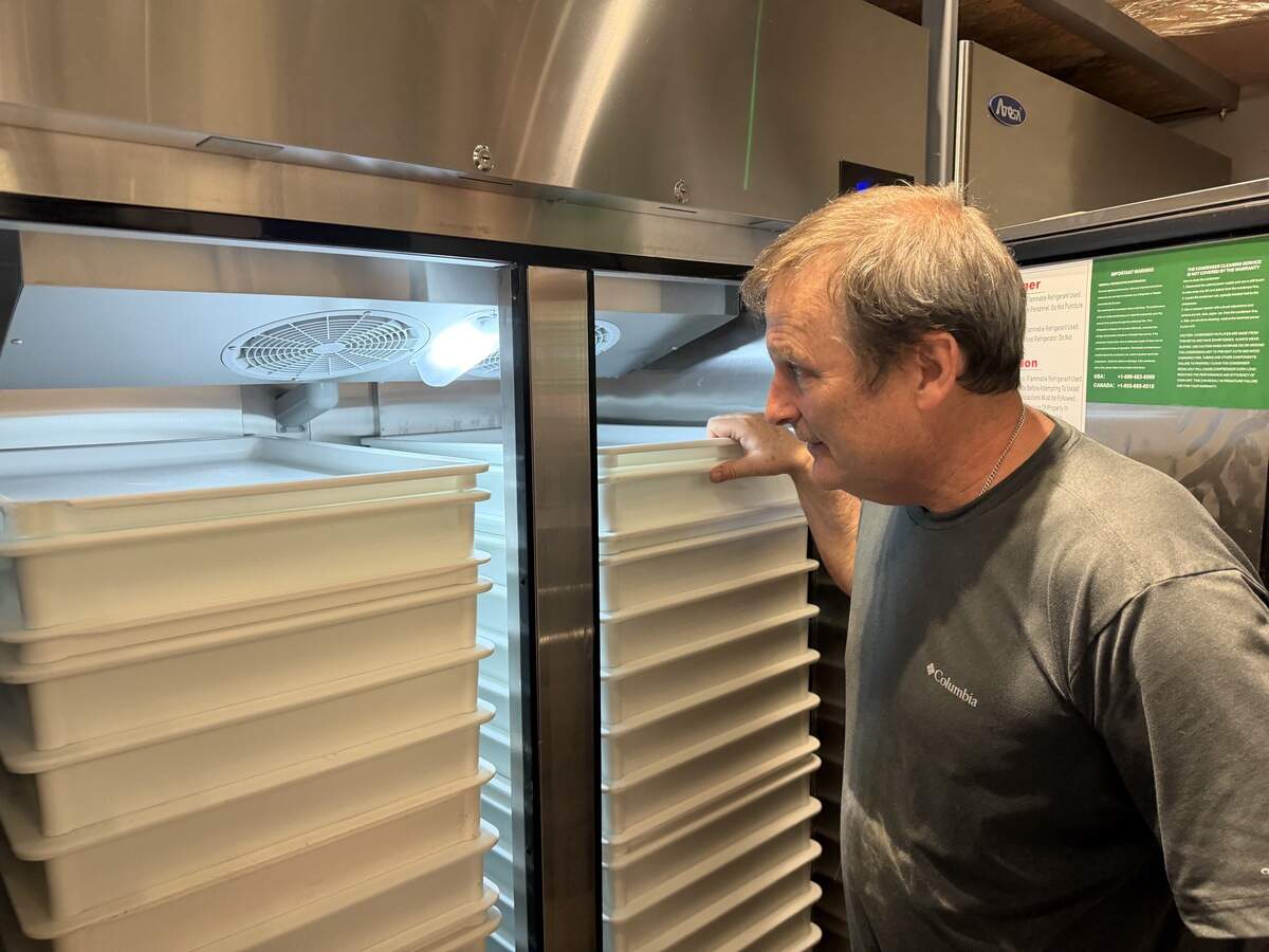 Tom Geagan, owner of Tommy’s Apizza, checks on his dough supply in the back of his restaurant at 2330 E. Douglas.