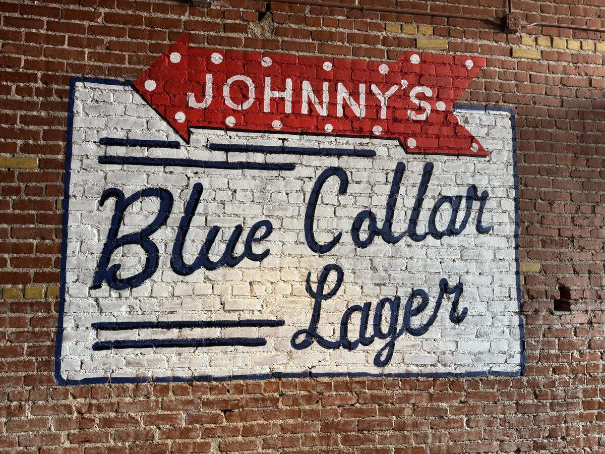 One of the murals already on the wall at Wichita’s soon-to-open Johnny’s Tavern touts its Blue Collar Lager, a beer brewed for Johnny’s by Lawrence’s Free State Brewing Co.