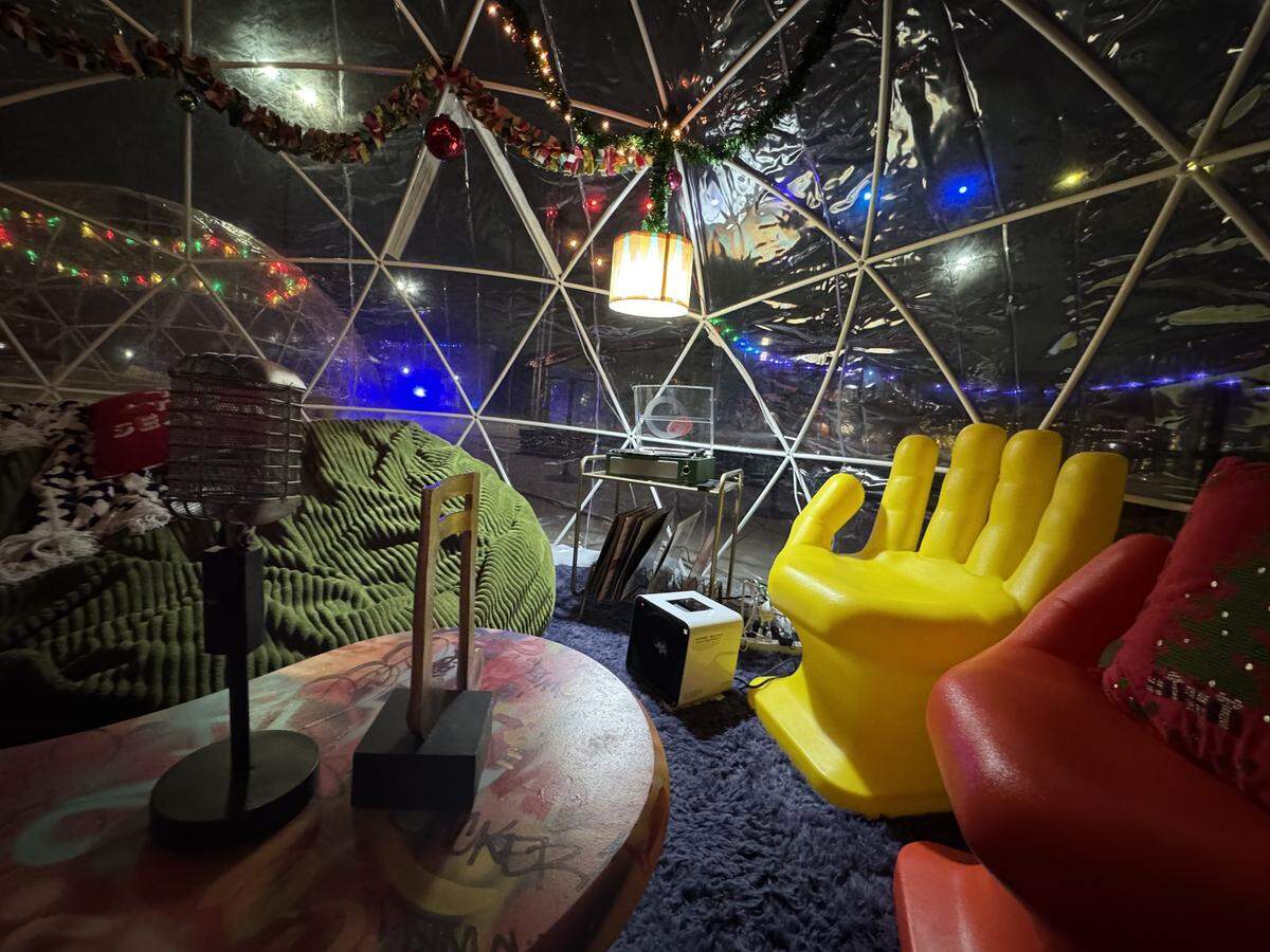 The Groovy Holiday Hut igloo at the Somewhere in Winter event is decorated with 1970s decor and has an old-school record player that visitors can use.