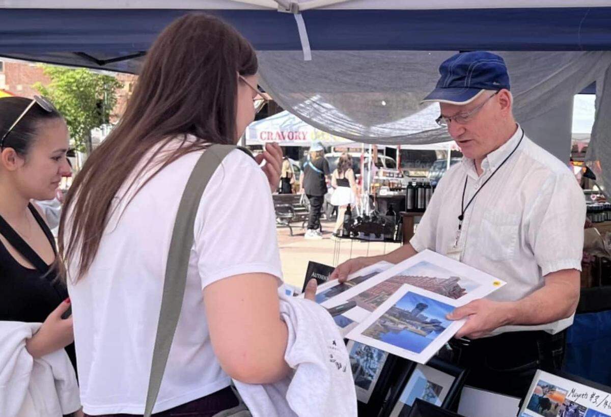 Painter Bill Goffrier, right, talks to Old Town Farm & Art Market shoppers at his booth.