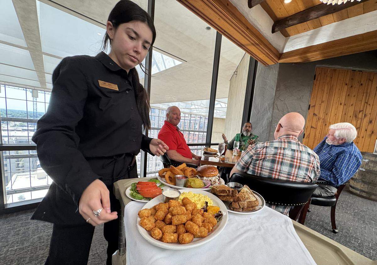 Ninth Floor Club members meet for lunch in the club’s new dining room, which was built inside an old storage area but has skylights and sweeping views of downtown Wichita.