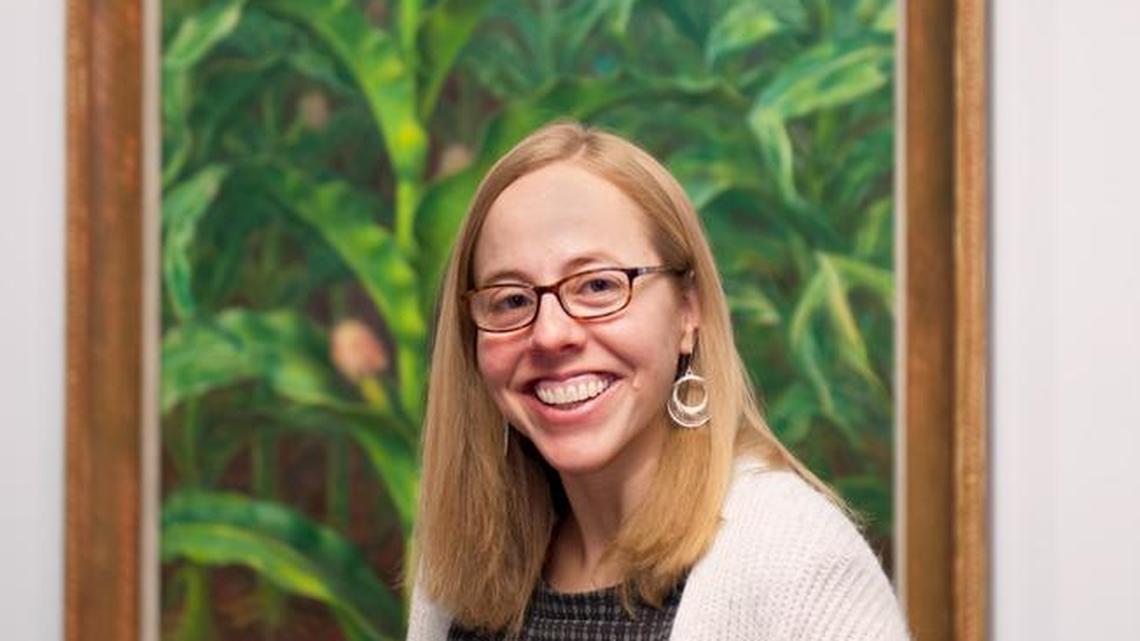 Tera Hedrick, a graduate of East High, is the new curator of the Wichita Art Museum, seen here in front of John Steuart Curry’s “Kansas Cornfield.”