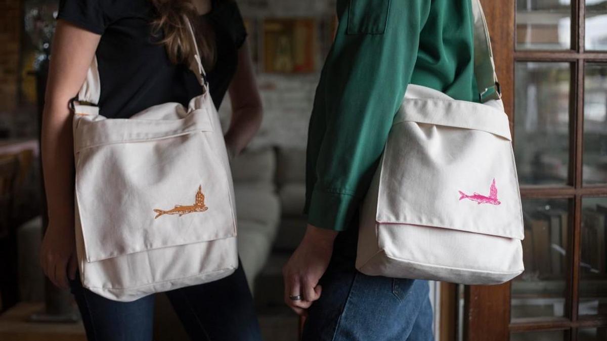 Georgia and Torin Andersen model Fisch Haus messenger bags, the gallery’s first attempt at merchandise sales. The bags are handmade by local seamstress Valerie Young.