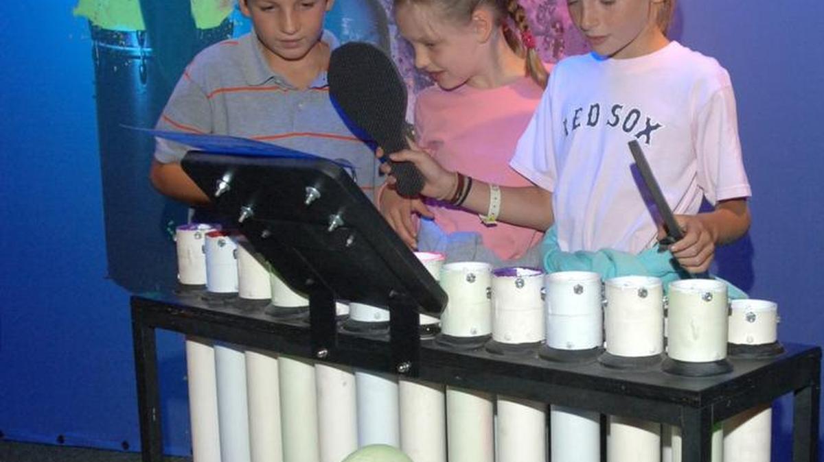 Kids try out making music on PVC pipes as part of the “Blue Man Group — Making Waves” exhibit opening Saturday at Exploration Place.
