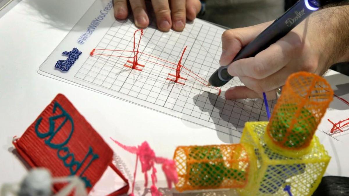 Maxwell Bogue, co-founder of WobbleWorks, uses a 3Doodler, a 3-D printing pen, to create a bridge during a preview of products at CE Week in New York.