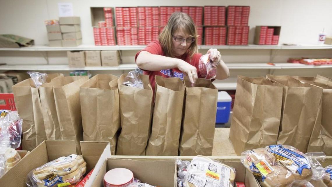 A volunteer at the United Methodist Urban Ministries Open Door food pantry prepares sacks of food at the center in 2011.