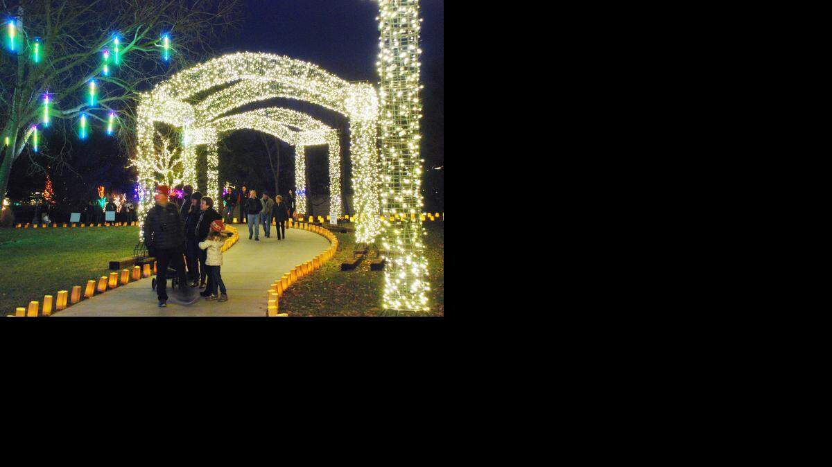
 People walk under the lighted arches for Illuminations at Botanica Gardens. 
