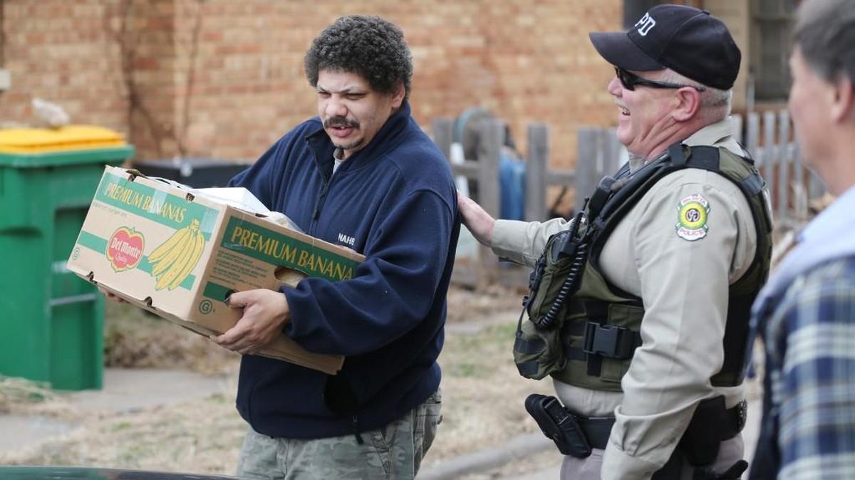 Wichita police Officer Steve Jerrell delivers food to Fred Rogers and his family last year.