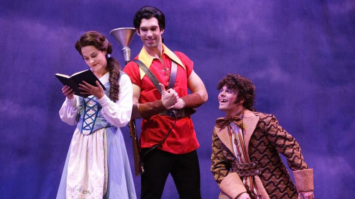Belle (Catherine Charlebois) shows a distinct lack of interest in Gaston (Johnny Stellard), accompanied by his doting friend Lefou (Tanner Pflueger).