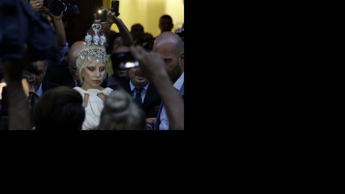 
Lady Gaga is surrounded by media and supporters, as she leaves a central Athens hotel to perform at the Olympic Stadium, in the Greek capital on Friday. (Sept. 19)
