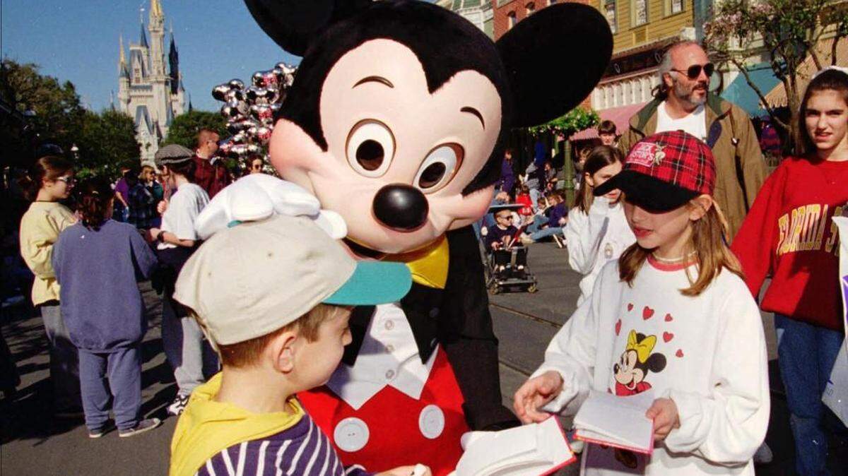 File photo – Mickey Mouse greets visitors to the Magic Kingdom in this file in Lake Buena Vista, Fla.