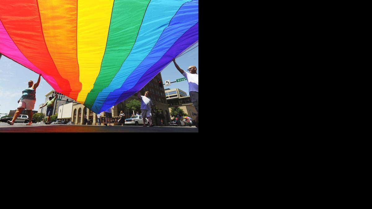 
People carry a large rainbow flag while marching during a gay pride parade in Wichita.
