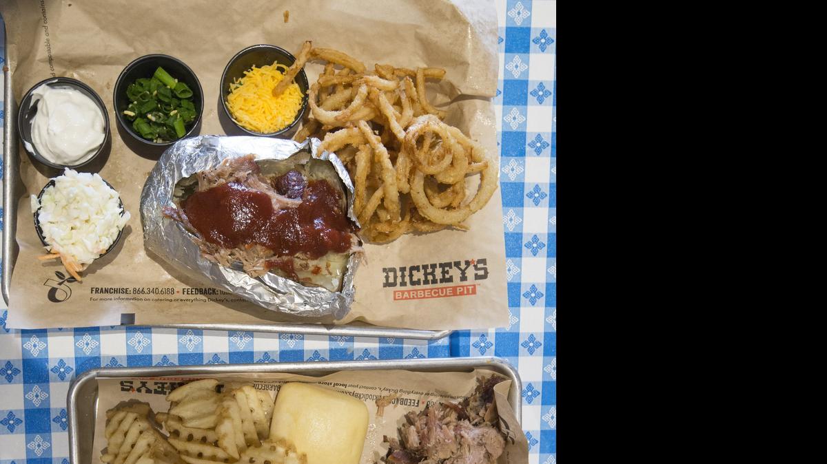 
Two meals from Dickey’s Barbecue Pit: Above is a pork-and-tangler baked potato, and below is a three-meat plate with turkey, brisket, pulled pork, mac and cheese, waffle fries and a yeast roll.
