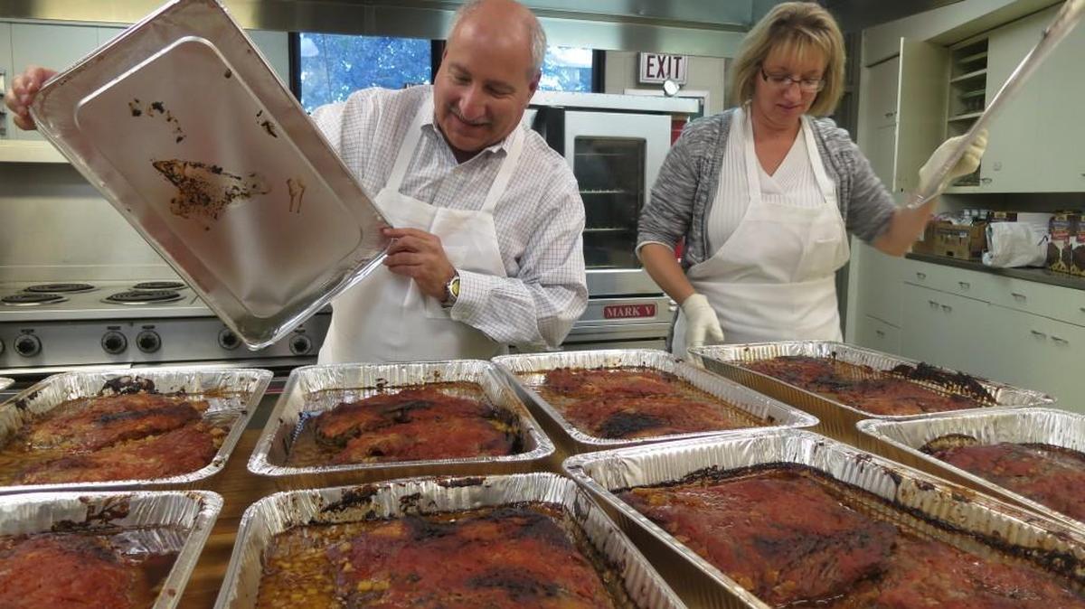 Scott Redler, left, and Cyndie Ponder tend to the 82 briskets cooking in their temple kitchen that will be served at Sunday’s Jewish Deli Day.
