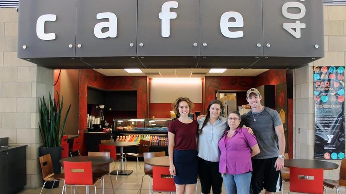 Mead’s Corner employees pose in front of the new space inside the Downtown YMCA on Monday.