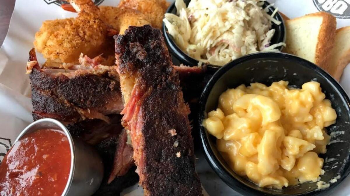 The “surf and swine” combo comes with a serving of fried shrimp or fried catfish, two sides, a dill pickle slice and some white toast, as well as a choice of pork selections.