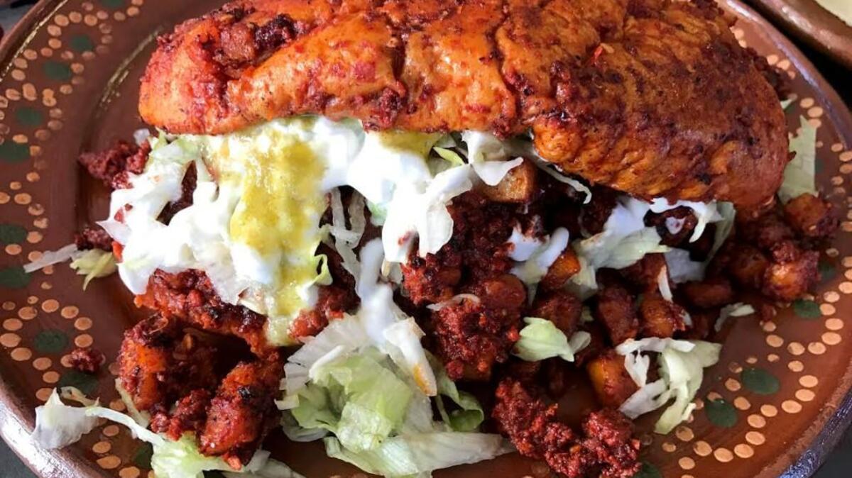 Los Compadres’ el pambaso is a popular Mexican street food that features bread dipped in red sauce, then filled with potatoes and chorizo.