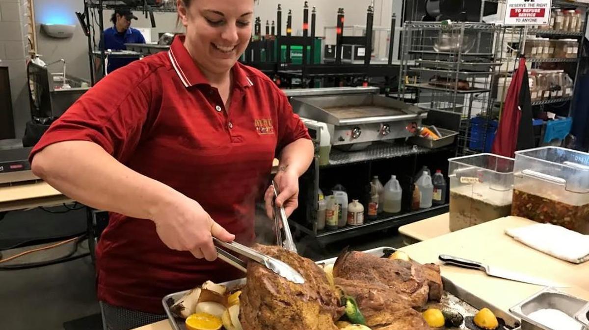 Cirque du Soleil’s traveling chef Kathryn Irwin carves brisket for Cuban sandwiches she’ll serve to the Cirque do Soleil cast and crew.