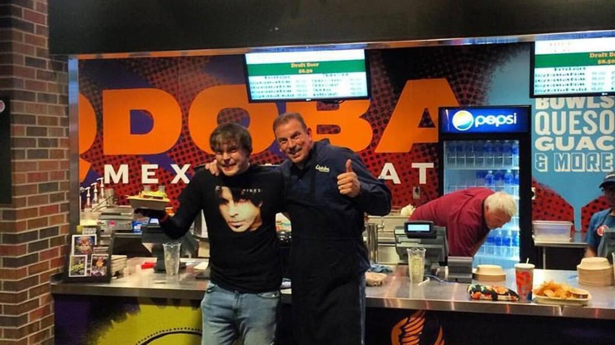 Qdoba franchisee Eric Estes, right, and his brother, Jared, outside the new Qdoba kiosk in Intrust Bank Arena.