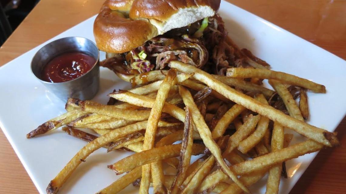 The Hungry Heart’s pulled-pork sandwich has a mustard-based barbecue sauce and is served on a pretzel bun.