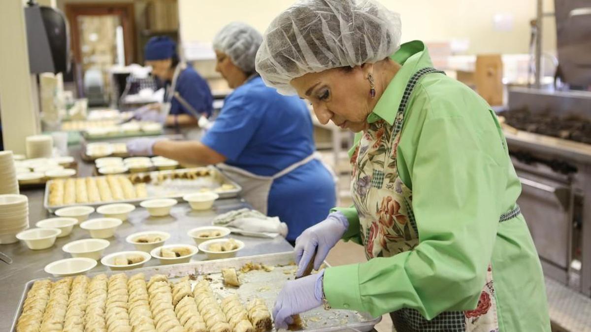 
Phyllis Abraham cuts a tray of baklava for this weekend’s St. George Lebanese dinner. Abraham is co-chairwoman of the event. (Oct. 7, 2015)
