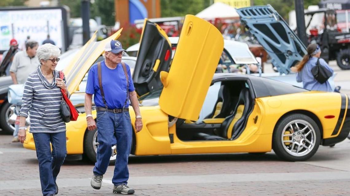 A couple checks out the cars along Douglas in front of Century II as they take in the BlackTop Nationals. (Aug. 21, 2015)