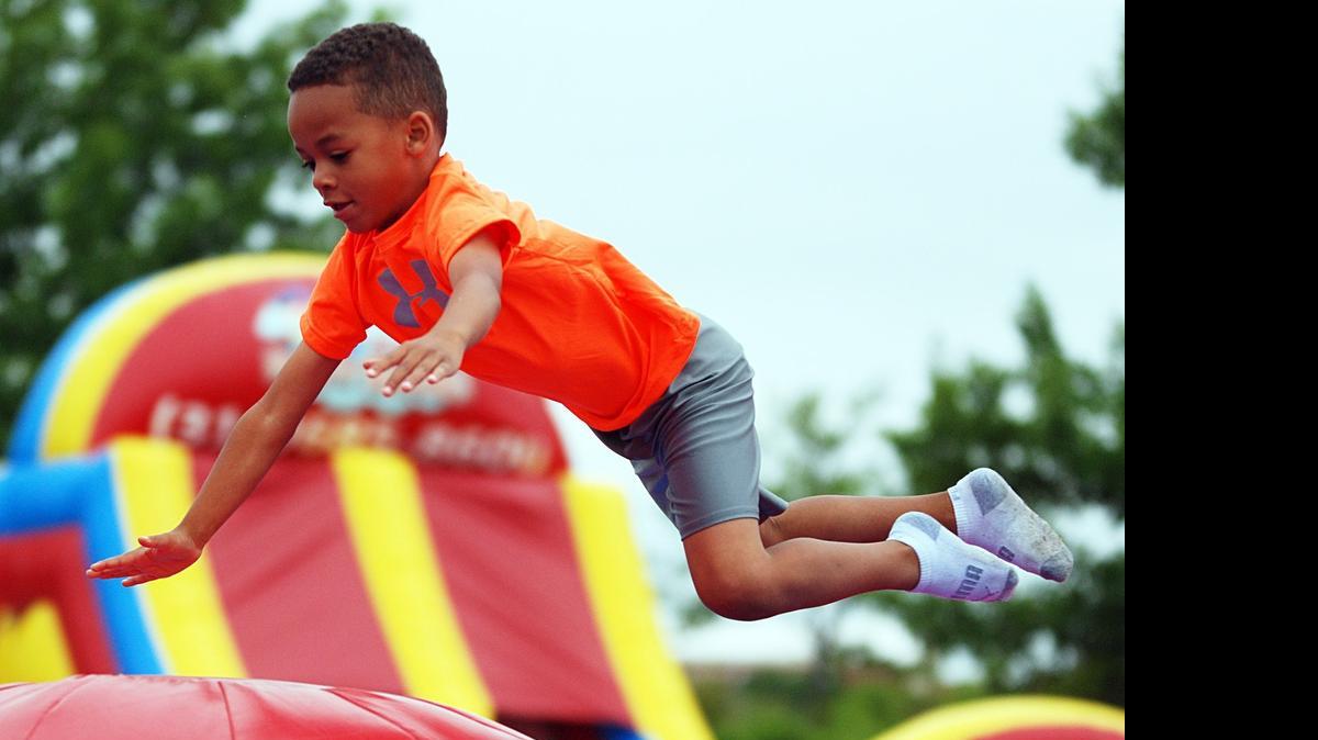 
Keshaun Kafaamveka bounces on an inflatable ball Saturday during Kids Corner at the Wichita Riverfest.
