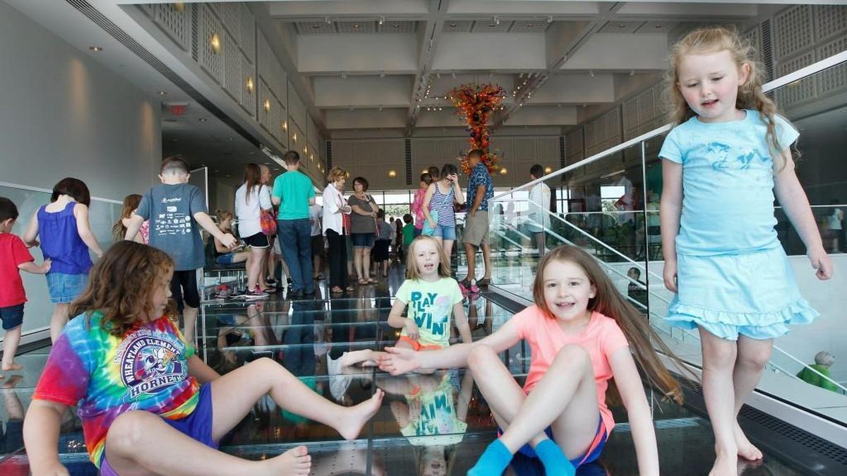 Children play on the glass floor that houses some of Dale Chihuly’s structural glass artwork during the Wichita Art Museum’s birthday celebration in 2015. (July 18, 2015)