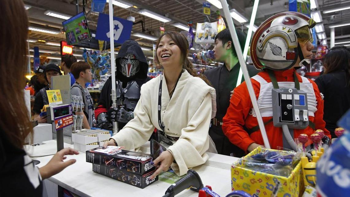 
Fans dressed as Star Wars characters shop at a toy store at midnight in Hong Kong, Friday, Sept. 4, 2015 as part of the global event called "Force Friday" to release new Star Wars toys and other merchandise of the new movie "Star Wars: The Force Awakens". The massive marketing blitz spans all kinds of media and included an 18-hour global “unboxing” streamed live on YouTube. 
