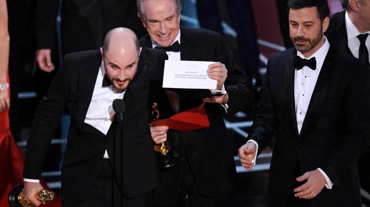Jordan Horowitz, producer of “La La Land,” shows the envelope revealing “Moonlight” as the true winner of best picture at the Oscars in 2017. Presenter Warren Beatty and host Jimmy Kimmel look on from right.