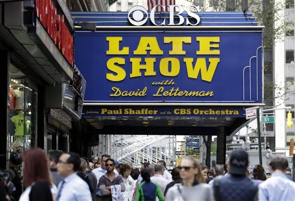 People gather under the marquee of the Ed Sullivan Theater in New York, Wednesday, May 20, 2015. After 33 years and 6,028 broadcasts of his late-night show, David Letterman is retiring.