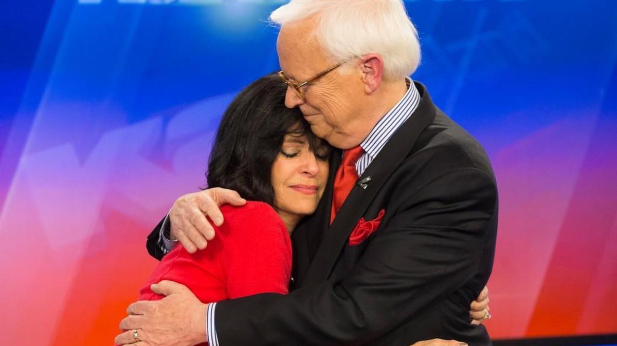 Larry Hatteberg and his co-anchor Susan Peters hug after Hatteberg signed off for the final time in 2014