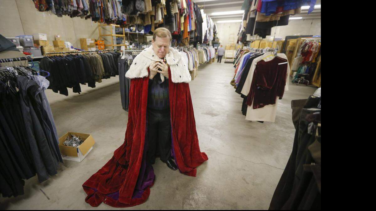 
Music Theatre Wichita artistic director Wayne Bryan tries on a costume from the musical "Me and My Girl" that's stored inside an enormous two story warehouse where the group’s sets are stored. The warehouse will be open for tours on Friday.
