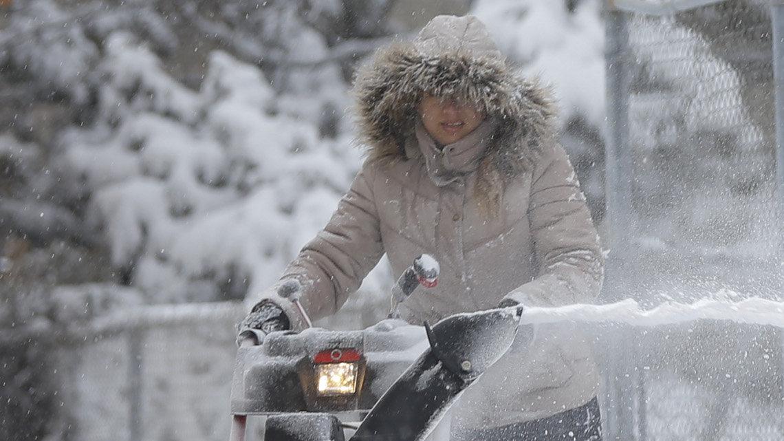 Michael Angelo Chavez has fun while his mother Ana runs a snowblower outside of their Benjamin Hills home on Tuesday. 