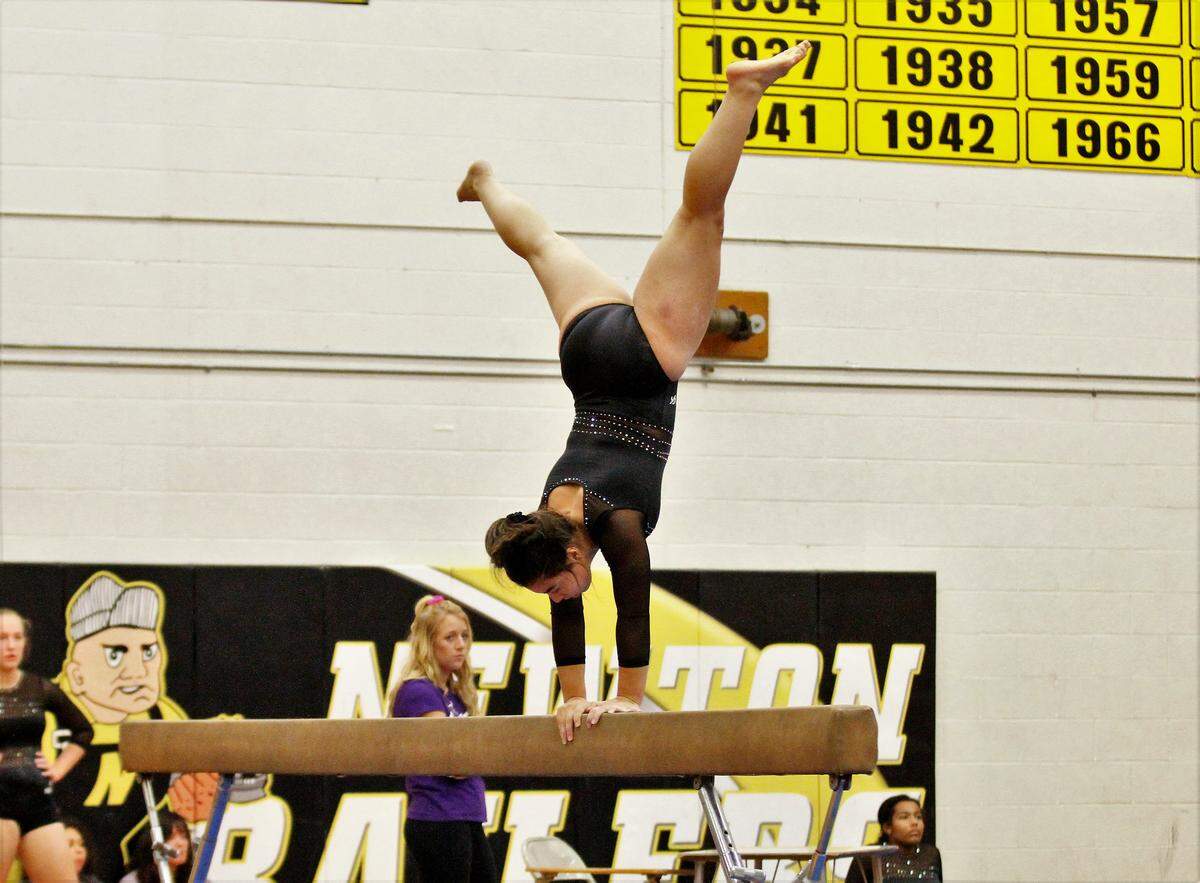 Newton sophomore Toria Thaw goes upside down during her balance beam routine against Emporia on Monday. (Oct. 8, 2018)