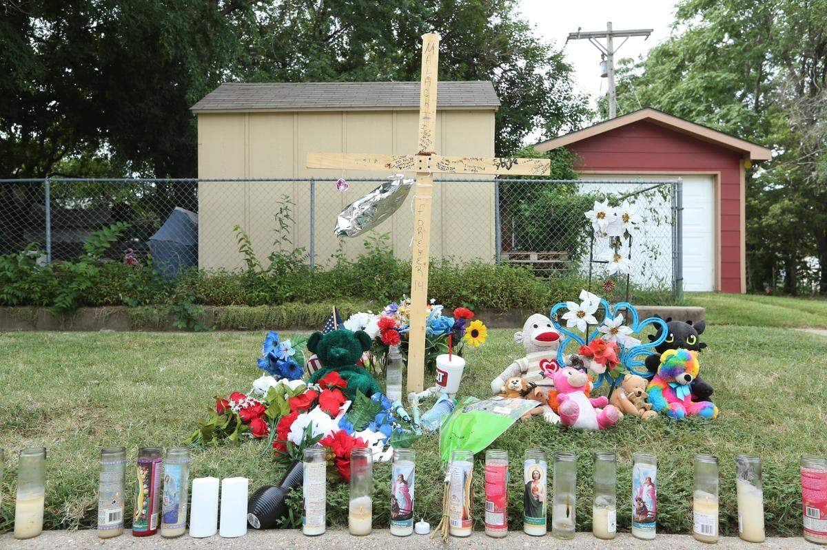 A memorial of candles, flowers and teddy bears sits directly across Skyline Park in an area where police say Sicka was shot and killed.