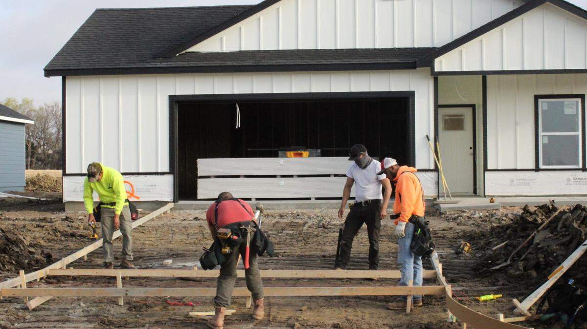 Construction workers prepare the future driveway of a home built by Liberty Communities in southeast Wichita.