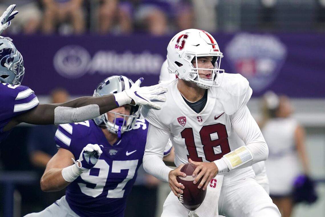 Stanford quarterback Tanner McKee (18) is pressured by Stanford defensive end Aaron Armitage (97) and others as he prepares to throw a pass in the first half of an NCAA college football game in Arlington, Texas, Saturday, Sept. 4, 2021. (AP Photo/Tony Gutierrez)