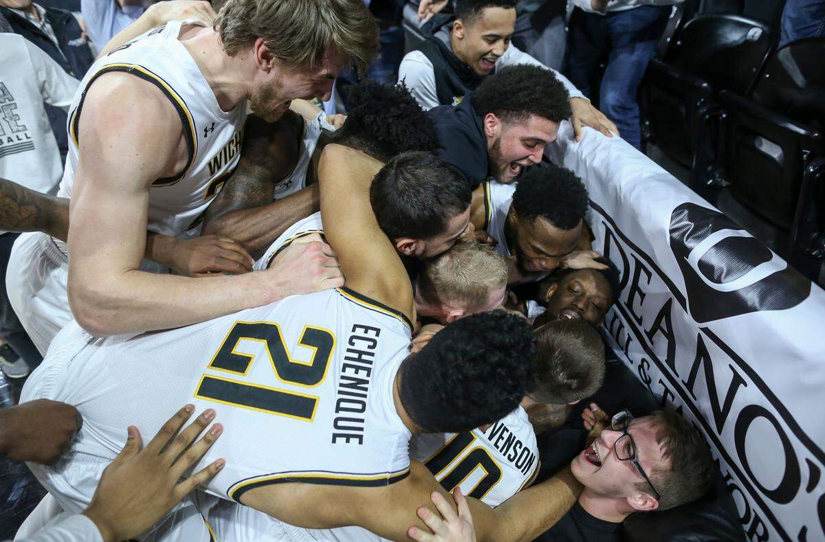 Wichita State players jumped on teammate Samajae Haynes-Jones after Haynes-Jones hit the game-winning shot as time expired against UConn at Koch Arena on Thursday.