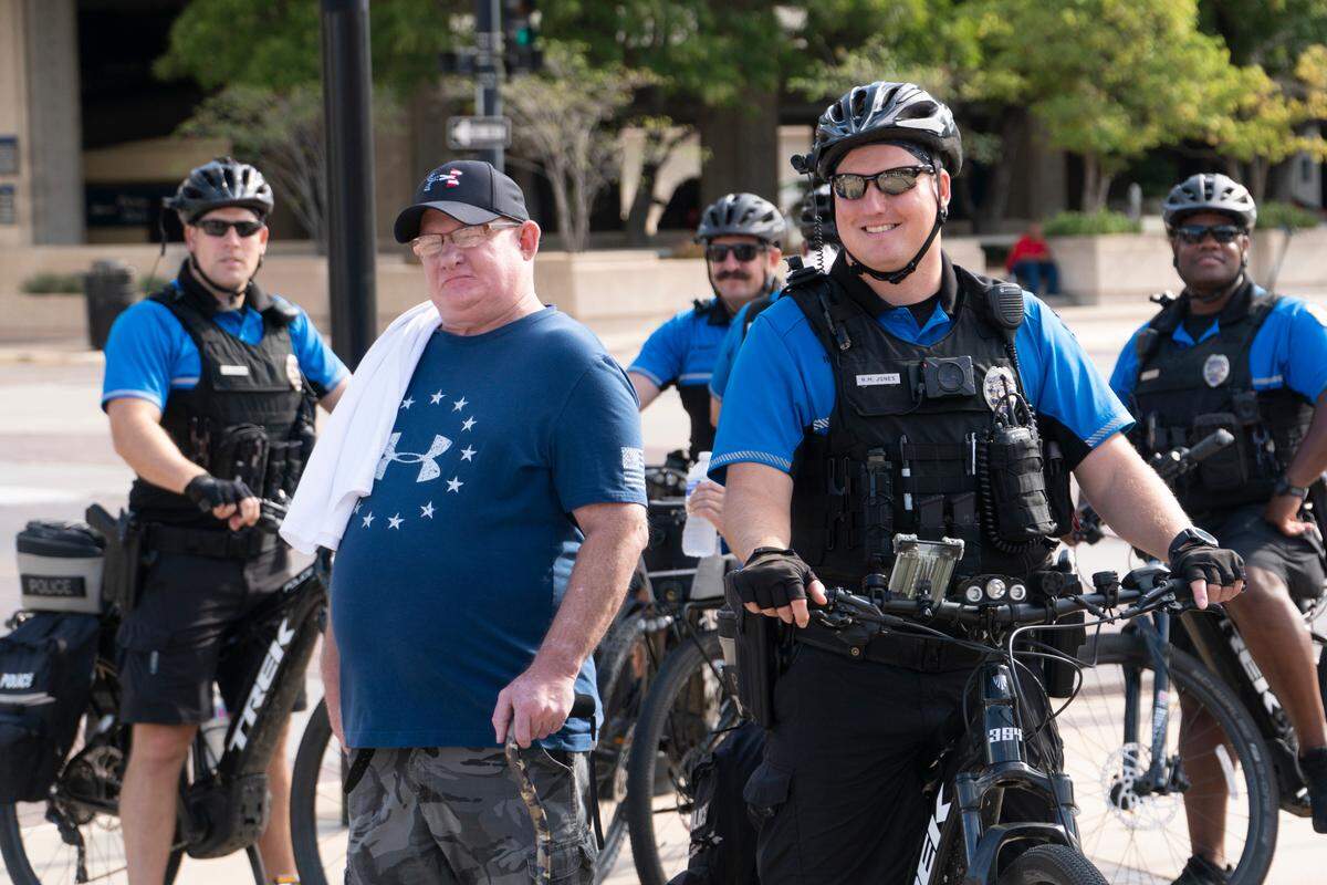 Around 200 people attended the “Back our Blue” rally on Kennedy Plaza in front of Century II to show their support for police officers. This man posed for a photo with Wichita police officers. (August 11, 2020)