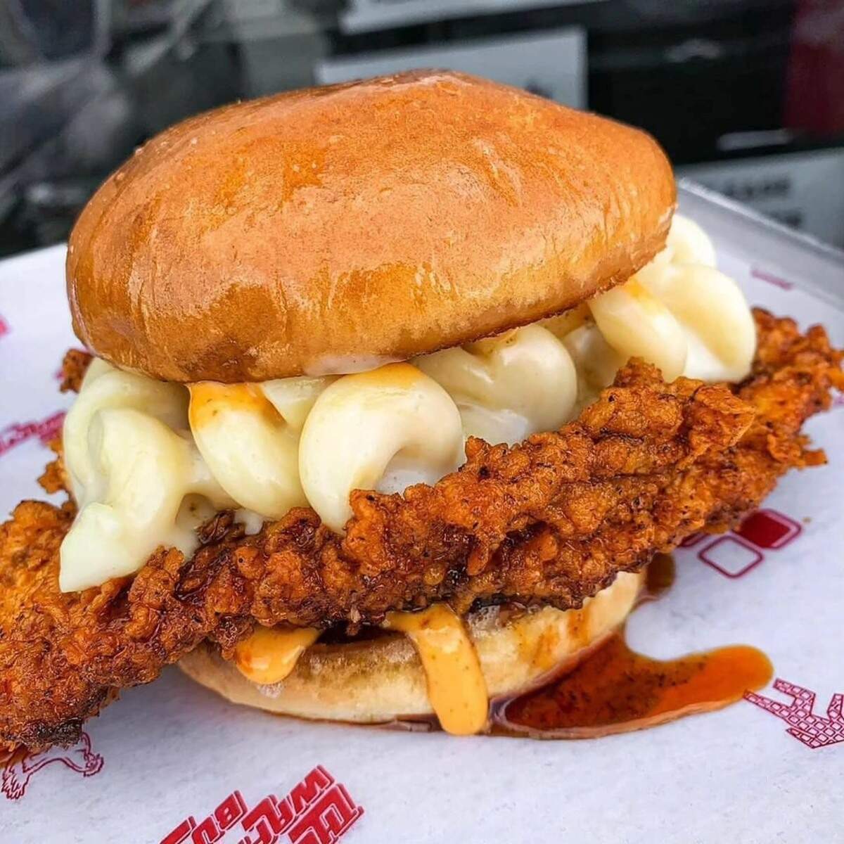 The MacDaddy Hot Chicken Sandwich at The Waffle Bus is topped with white cheddar mac and cheese and thunder sauce.