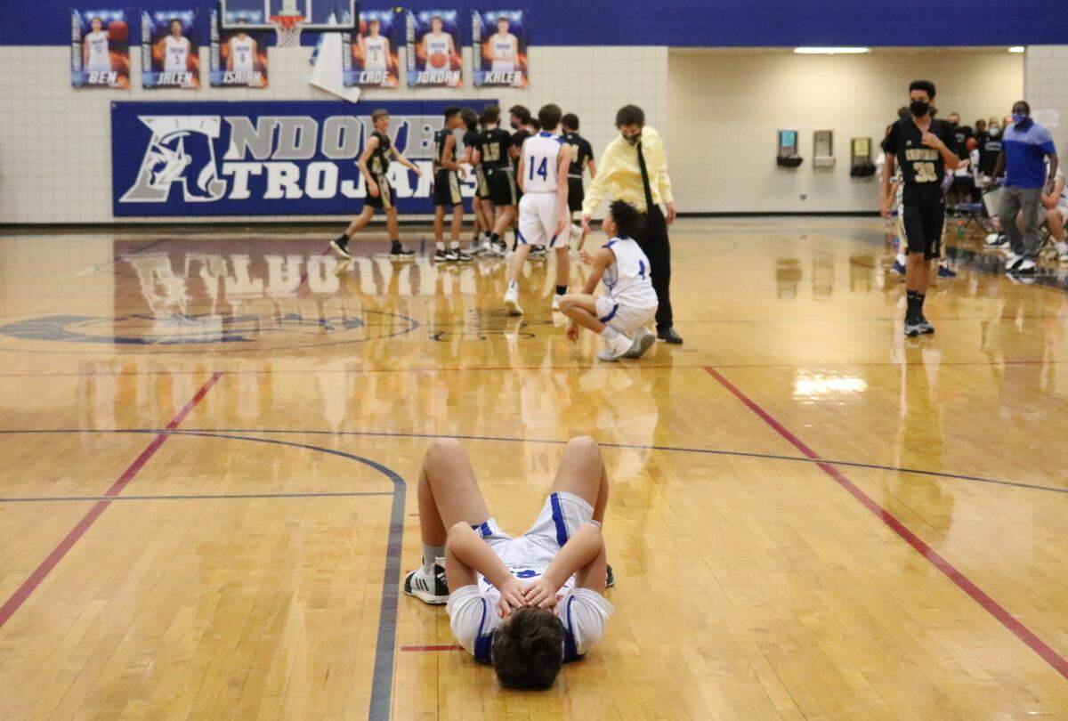 Andover High School freshman basketball player Jackson Peck lies on the court Jan. 15, 2021 after losing to cross-town rival Andover Central High School on a three-point shot at the buzzer. Central was down 54-56 with four seconds to go when Central’s Landon Kitterman hit the three pointer to win the game 57-56.