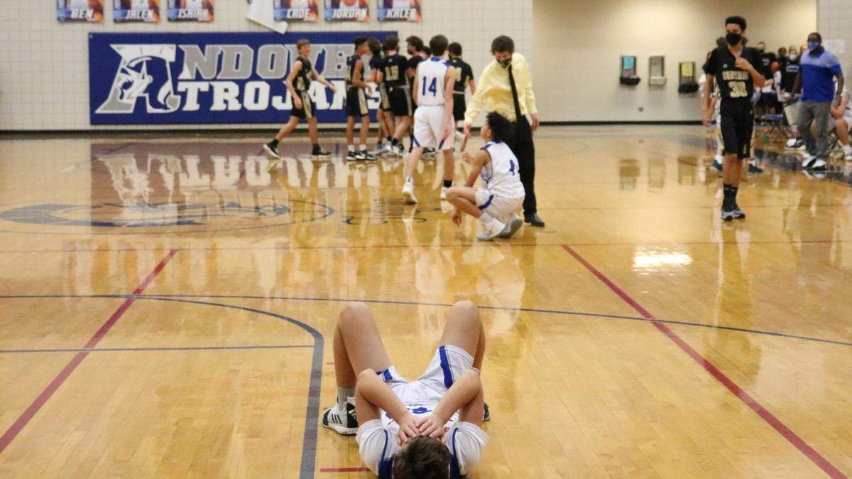 Andover High School freshman basketball player Jackson Peck lies on the court Jan. 15, 2021 after losing to cross-town rival Andover Central High School on a three-point shot at the buzzer. Central was down 54-56 with four seconds to go when Central’s Landon Kitterman hit the three pointer to win the game 57-56.