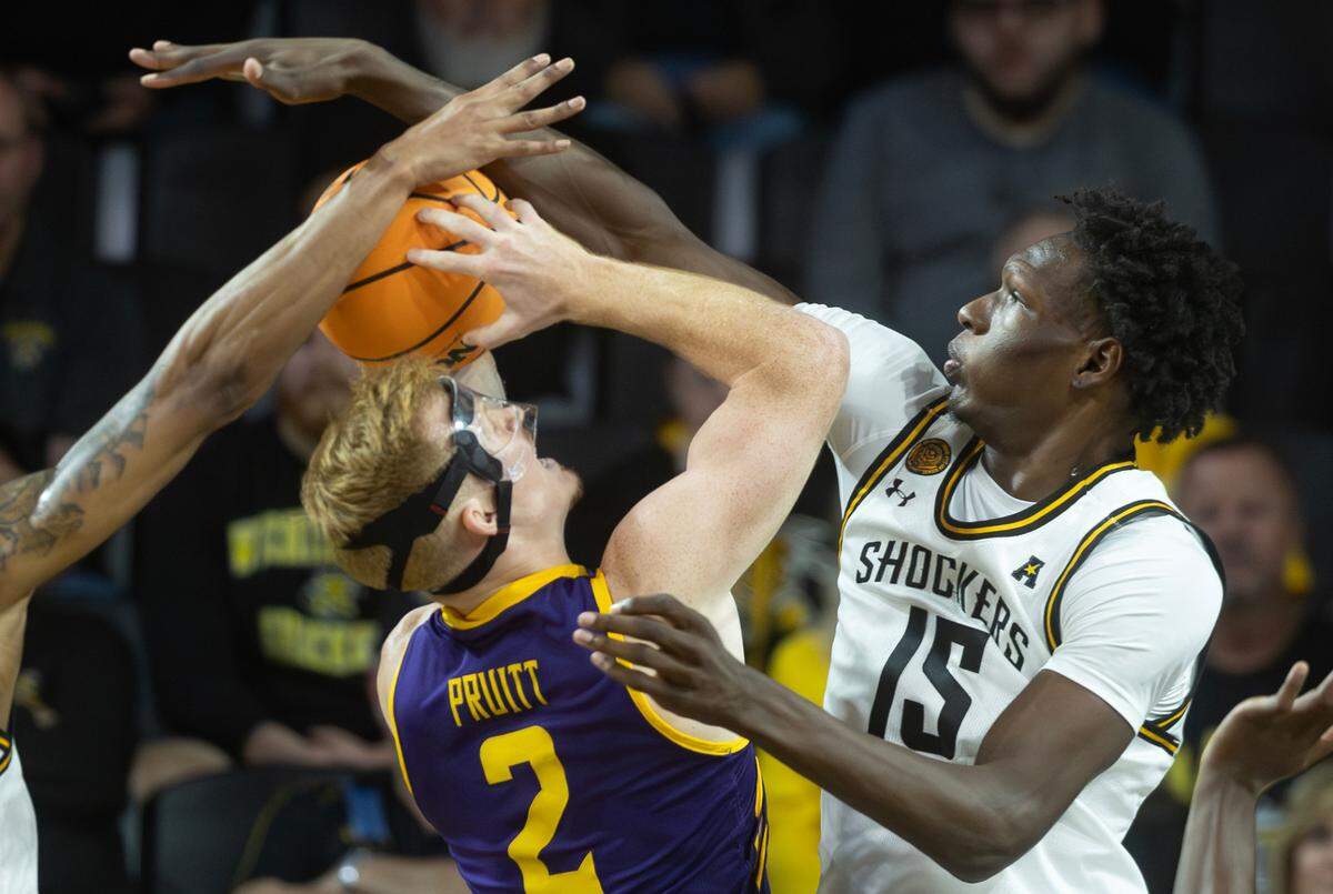 Wichita State’s Ballard blocks the shots of Lipscomb’s Will Pruitt during the first half of their season opener on Monday night at Koch Arena.